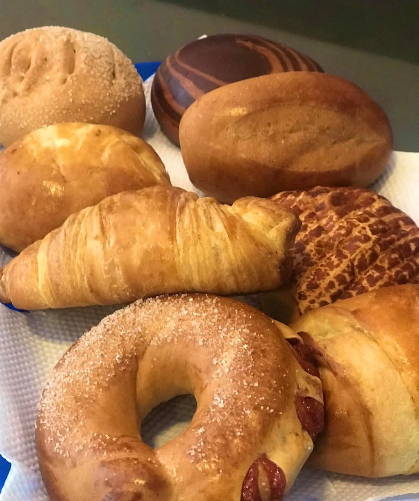 Pan surtido recién horneado: croissant, roscón azucarado y panes de la casa